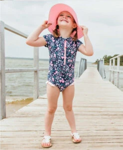RuffleButts Girls Moonlit Meadow Short Sleeve One Piece Rash Guard -Baby Go Round Store rgsnvxx mmsz rufflebutts navy pink floral short sleeve one piece rash guard girls swimsuit